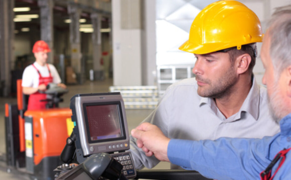 male inspector looking at screen with operator in warehouse