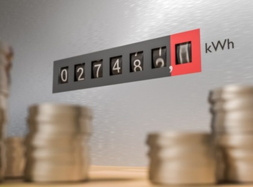 Expensive energy and power consumption concept. Coins in front of electricity meter.