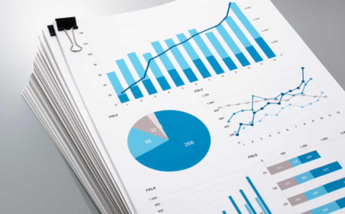 Pile of documents on gray reflection background. Many graphs and charts. Concept image of data gathering.