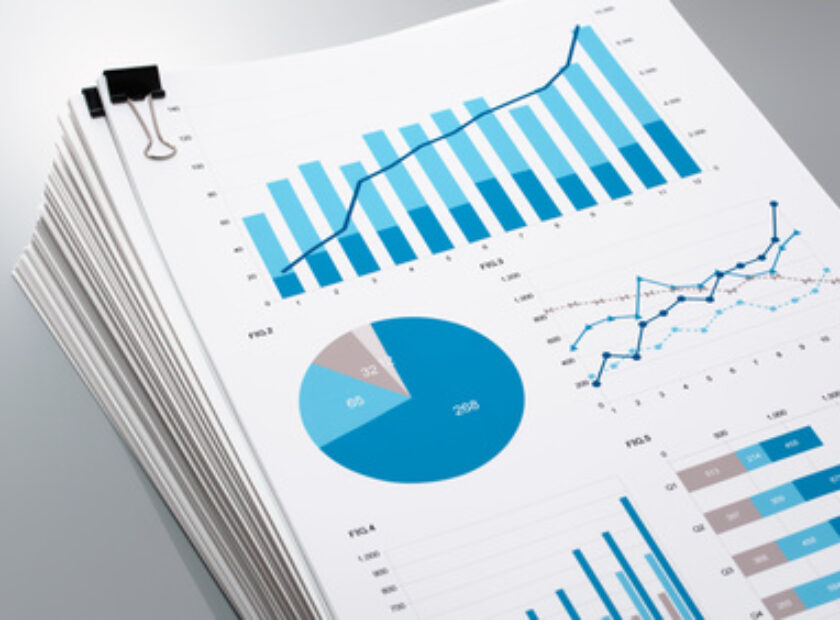 Pile of documents on gray reflection background. Many graphs and charts. Concept image of data gathering.
