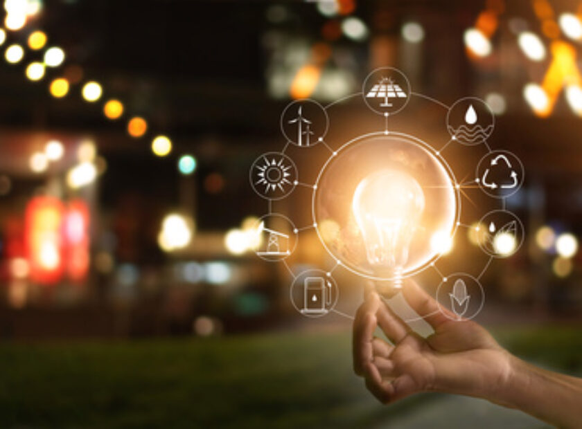 Hand holding light bulb in front of global, show the world's consumption with icons energy sources for renewable, Ecology concept. Elements of this image furnished by NASA.